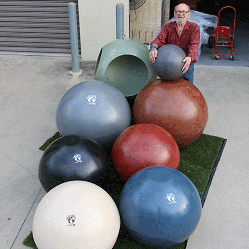 man standing with big plastic balls
